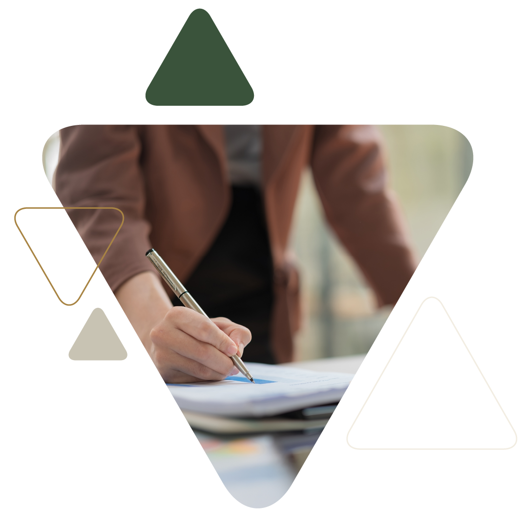 Person writing on documents at desk
